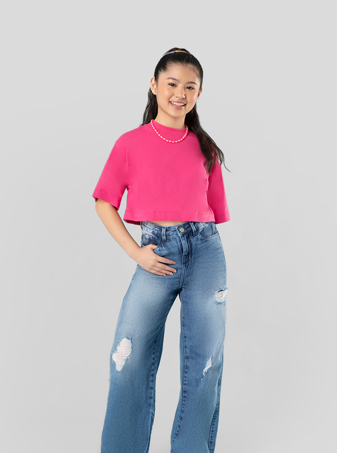 Menina usando calça jeans e camiseta rosa