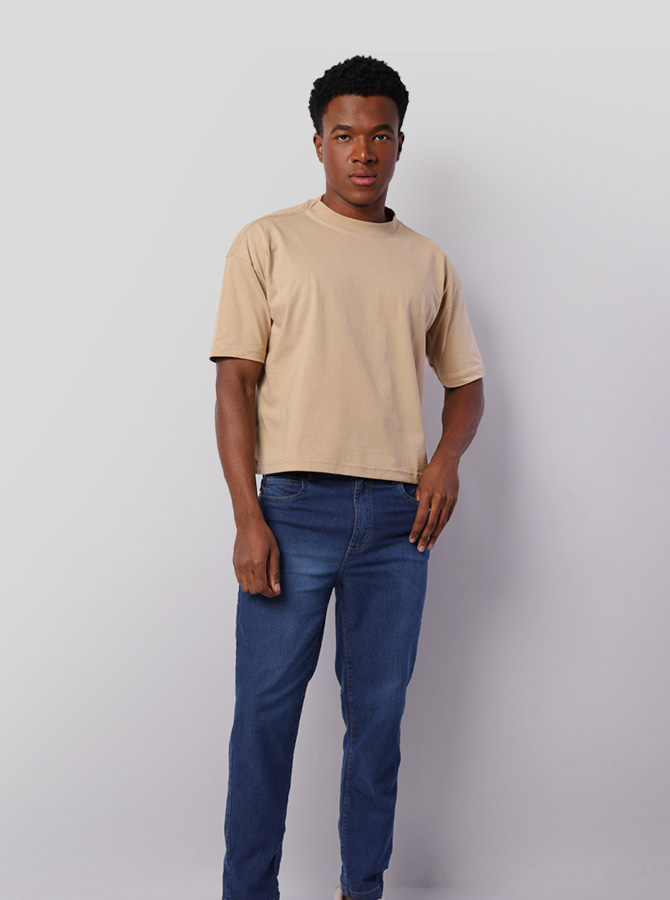Homem usando calça jeans e camiseta bege